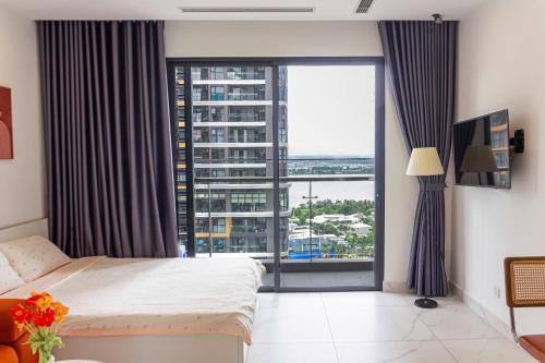 a bedroom with a bed and a large window at Honey Vinhomes in Long Bình