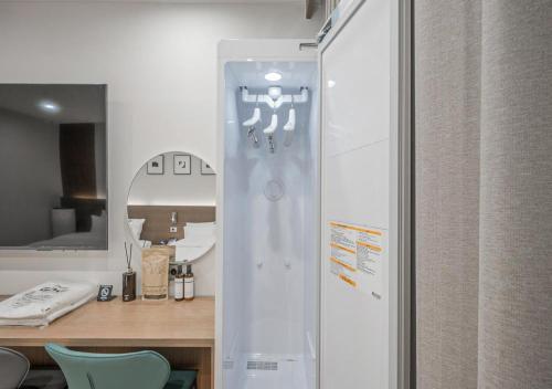 a bathroom with a glass door with a mirror at Lantana Daegu Shinam Branch in Daegu