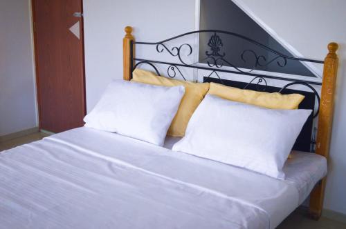 a bed with two white pillows and a black headboard at Gilbys Eco Bungalow in Udaweliwitiya
