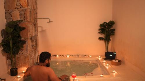 a man sitting in a bath tub with lights at Goya Hills 3BHK - Private Villa Udaipur in Udaipur
