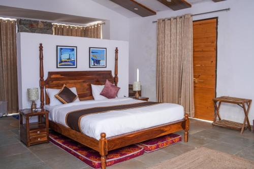 a bedroom with a large bed with a wooden headboard at Goya Hills 3BHK - Private Villa Udaipur in Udaipur