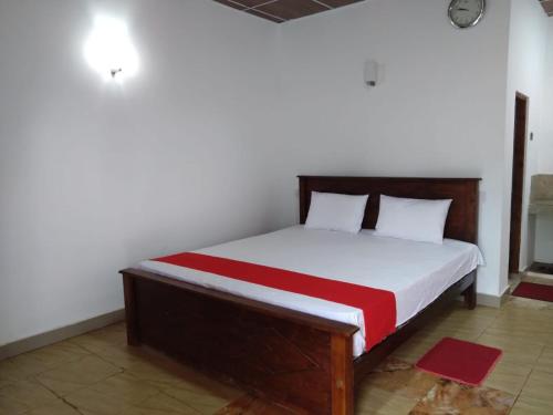 a bedroom with a bed with white and red sheets at Lucknature Cabana Kandy in Elamalwewa