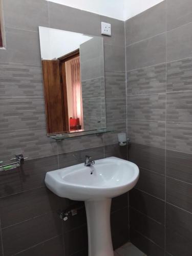 a bathroom with a sink and a mirror at Lucknature Cabana Kandy in Elamalwewa