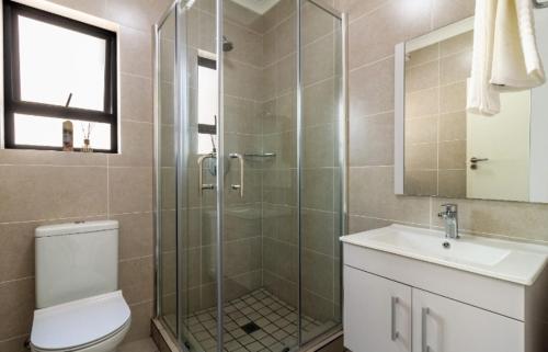 a bathroom with a shower and a toilet and a sink at AlimamaSpaces The Lavender in Northriding