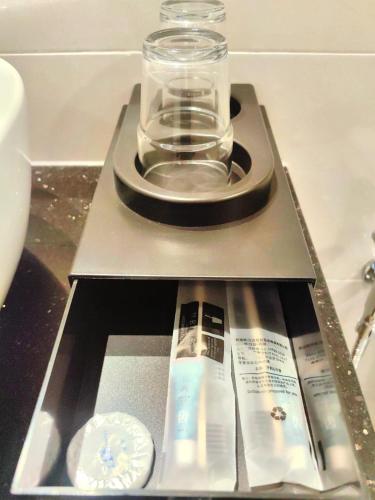 a shelf with a glass jar and a bottle of toothpaste at 118 Grand Hotel in George Town