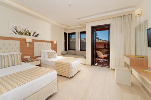 a hotel room with two beds and a television at Sundia By Liberty Suncity in Oludeniz
