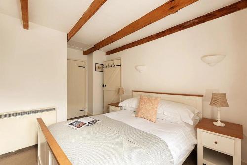 a bedroom with a bed with a book on it at Homelands in Port Isaac