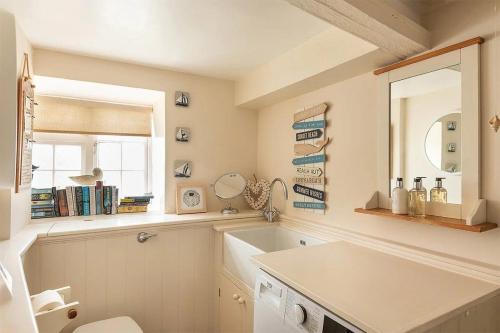 a bathroom with a sink and a mirror at Homelands in Port Isaac