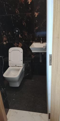 a bathroom with a toilet and a sink at Sansav Garden Resort in Gurpur