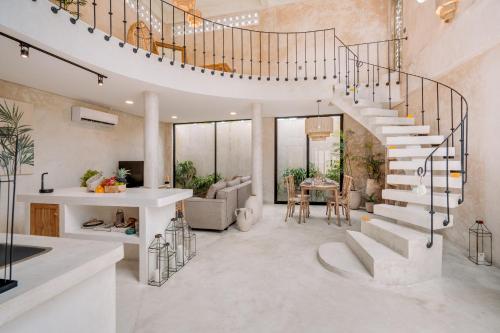 a spiral staircase in a living room with a table at South Villa Ungasan in Ungasan