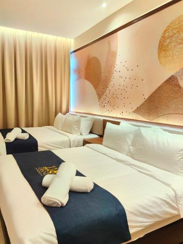 a hotel room with three beds and a painting on the wall at 118 Grand Hotel in George Town