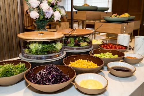 a buffet filled with bowls of different types of food at Atour Hotel Dalian Development Zone in Dalian
