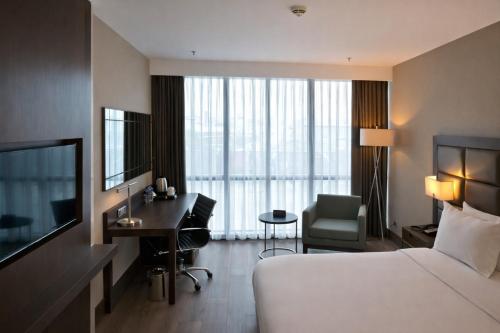 a hotel room with a bedroom with a bed and a desk at Prime Istanbul Residences in Istanbul