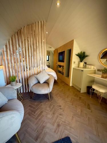 a room with two beds and a couch and a table at The Secret Garden Glamping Cornwall in Cury