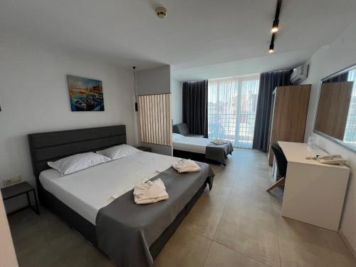 a bedroom with a large bed and a desk at Hotel Pacific Palma in Sunny Beach