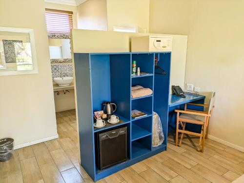a small kitchen with a blue cabinet with a sink at Sedia Hotel in Maun