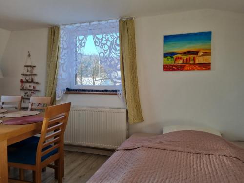 a bedroom with a bed and a table and a window at Sielanka pod Siglanami 2 in Wisła