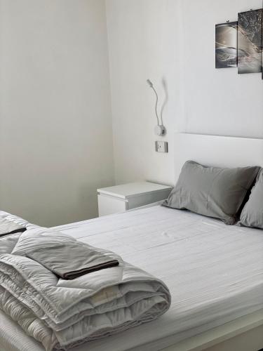 a white bedroom with a large bed with a white wall at Casa Piccola in Tremosine Sul Garda