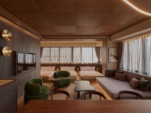 a room with two beds and a table and chairs at illi Aest Shinagawa-Gotanda in Tokyo
