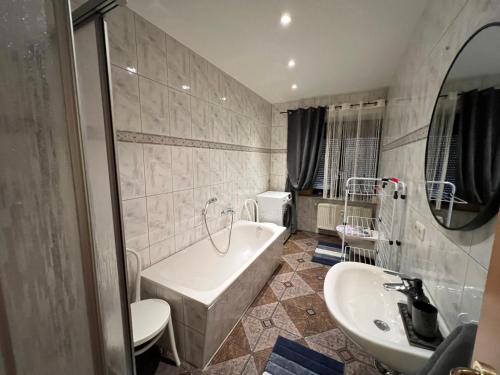 a bathroom with a tub and a sink at Villa Louis Hirsch in Gera