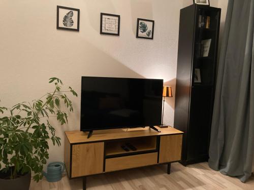 a flat screen tv sitting on top of a wooden entertainment center at Direkt am Südstrand! in Wilhelmshaven