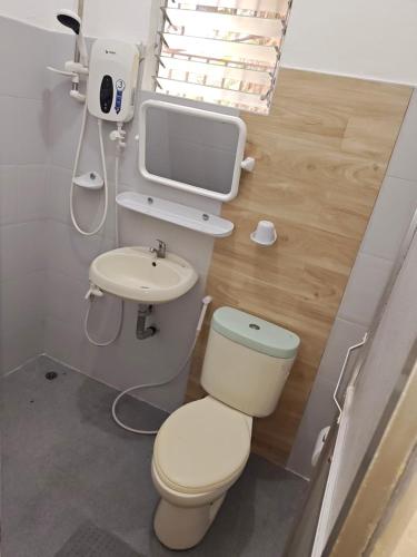 a small bathroom with a toilet and a sink at The Blue Pagong in Puerto Galera