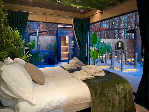 a bedroom with a bed and a large window at The Secret Garden Glamping Cornwall in Cury