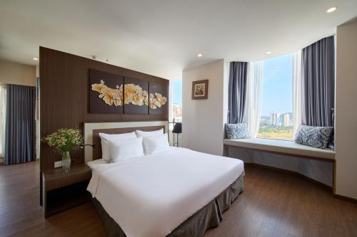 a hotel room with a large bed and a window at The Sol Hotel in Nha Trang