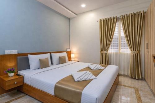 a bedroom with a large bed and a window at Hotel Chalet, Madiwala in Bangalore