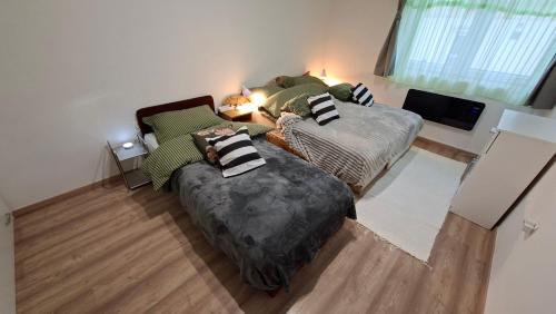 a living room with two beds and a couch at Tiszti Szálló Apartman in Verpelét