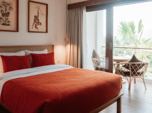 a bedroom with a bed and a table and a window at Porter Boutique Hotel & Lifestyle in Kuta Lombok