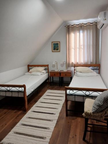 a bedroom with two beds and a table and a window at Apartamenty Polonia in Cserépfalu