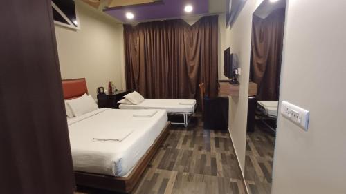 a hotel room with a bed and a tv at Hotel Sriram JB Residency in Virudunagar
