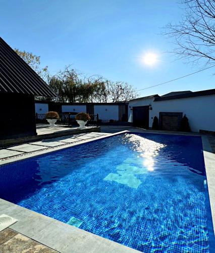 a large blue swimming pool next to a house at Black A-Frame Luxury Chalet & Pool in Gabala