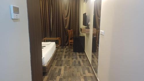 a room with a bed and a table and a television at Hotel Sriram JB Residency in Virudunagar