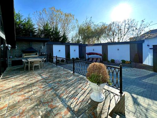 a patio with a table and a vase with a plant at Black A-Frame Luxury Chalet & Pool in Gabala