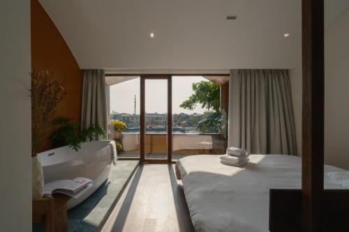 a bedroom with a tub and a bed and a bath room at Amea Homestay in Thôn Kim Long (1)