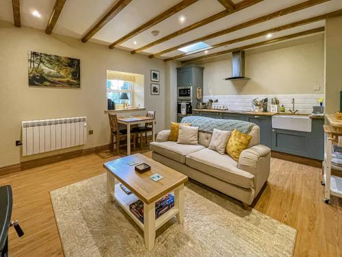 a living room with a couch and a table at Dragonfly Cottage-Uk39919 in Ballakinnag