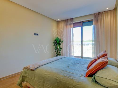 a bedroom with a bed with pillows and a window at Iris Agadir - Luxe - Piscine - 4 Px in Agadir