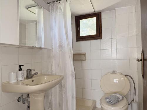 a white bathroom with a sink and a toilet at Xenius Zeus Apartments in Kriopigi in Kriopigi