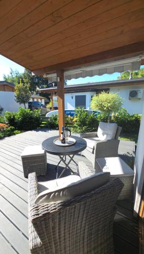 a patio with a table and chairs on a deck at Apartamenty Boszkowo Lakeside in Boszkowo