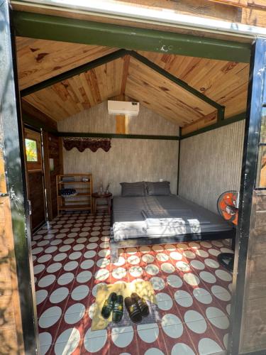 a bedroom with a bed in a room with a ceiling at The Forester Chalet in Buôn Pưk Prong