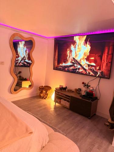 a living room with a fireplace and a tv at L'Interdite House - Limitless - Jacuzzi Cinema Love in Savigny-sur-Orge