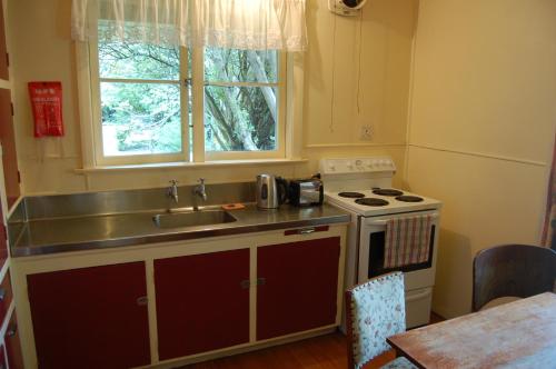 a kitchen with a sink and a stove and a window at Wheatly Downs Farmstay and Backpackers in Hawera