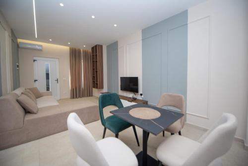 a living room with a couch and a table and chairs at White Arena Apartments GOLEM in Golem