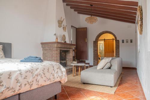 a bedroom with a bed and a fireplace at Cortijo el Sendero in Alora