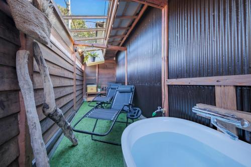 a room with a toilet and a group of chairs at 城ヶ島 浦ノ間邸 デザイナーズ古民家サウナヴィラ 富士山ビューBBqテラス付 in Miura