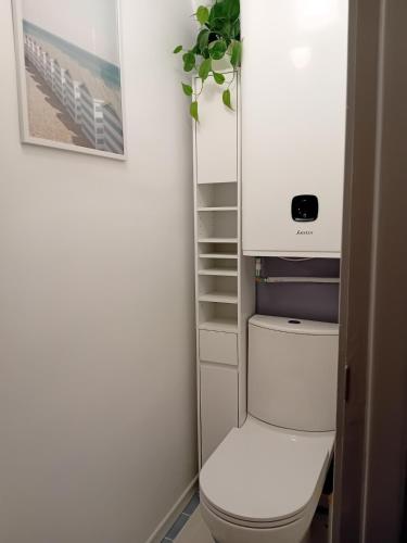 a bathroom with a white toilet in a room at La parenthèse 70's in Le Havre