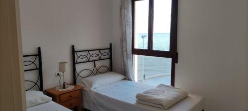 a bedroom with two beds and a window with the ocean at Brisa Mediterránea II, Topacio IV in Ifach