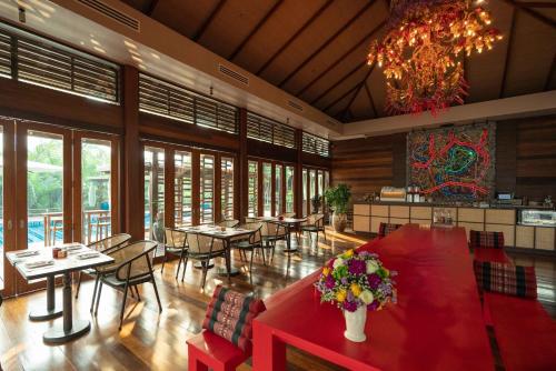 a restaurant with tables and chairs and a chandelier at Baan Krai Nao The Riverfront in Bangkok